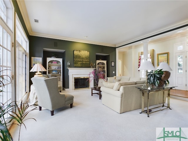 living room featuring light carpet, built in shelves, ornamental molding, and ornate columns