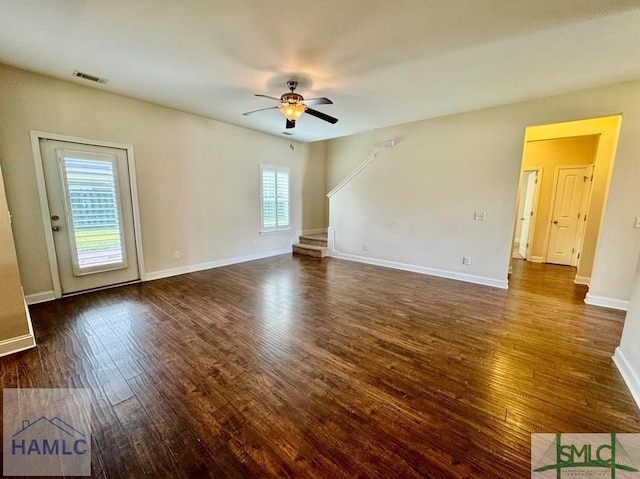 spare room with dark wood-type flooring, ceiling fan, and a healthy amount of sunlight