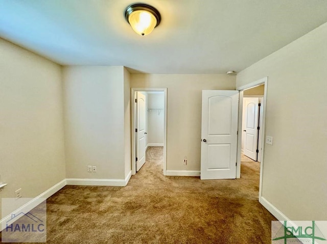 unfurnished bedroom with carpet, a closet, and a walk in closet