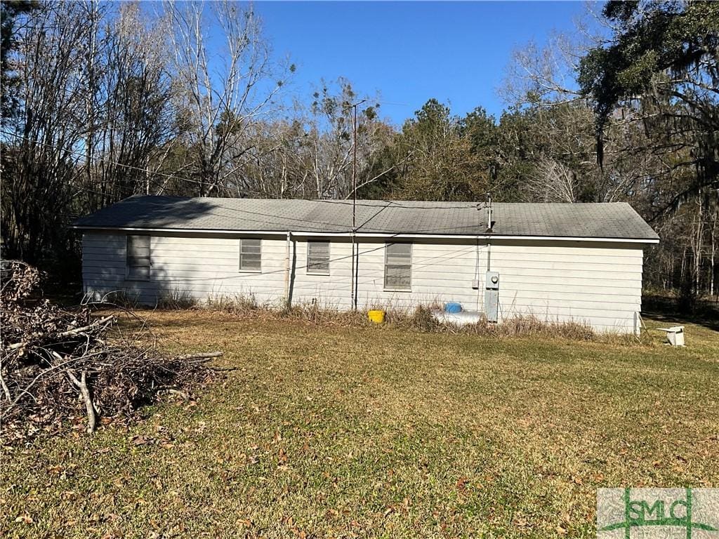 rear view of house featuring a lawn