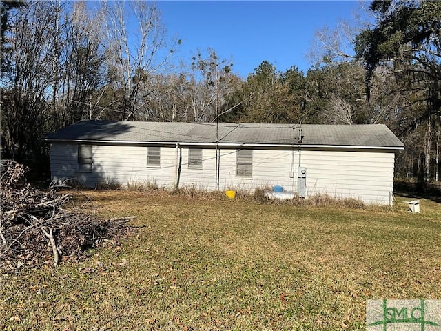 rear view of house featuring a lawn