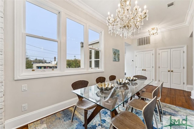 dining area featuring hardwood / wood-style flooring, ornamental molding, and a chandelier