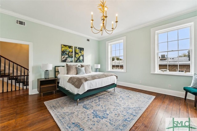 bedroom with a notable chandelier, crown molding, and dark wood-type flooring