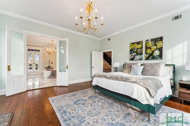 bedroom with an inviting chandelier, crown molding, dark wood-type flooring, ensuite bath, and french doors