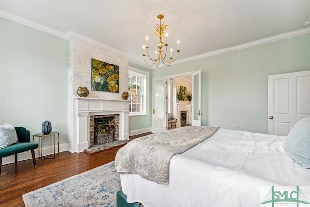 bedroom with a notable chandelier, dark wood-type flooring, a fireplace, and ornamental molding