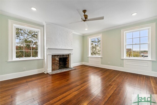 unfurnished living room with a brick fireplace, crown molding, ceiling fan, and hardwood / wood-style flooring