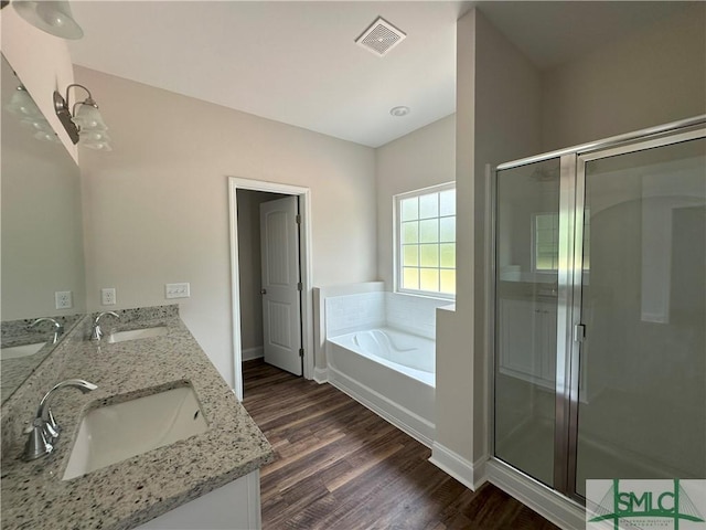 bathroom featuring wood-type flooring, vanity, and plus walk in shower