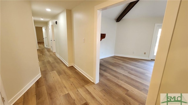 corridor featuring light hardwood / wood-style flooring and beamed ceiling