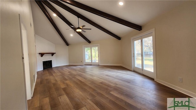 unfurnished living room featuring ceiling fan, vaulted ceiling with beams, plenty of natural light, and hardwood / wood-style flooring