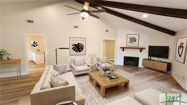 living room featuring ceiling fan, beam ceiling, hardwood / wood-style flooring, and high vaulted ceiling