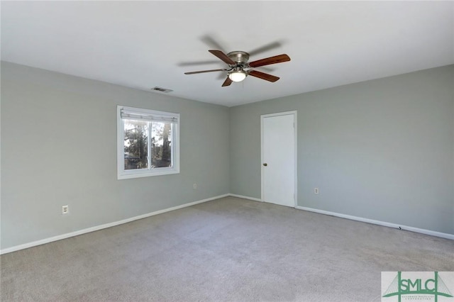 carpeted spare room featuring ceiling fan