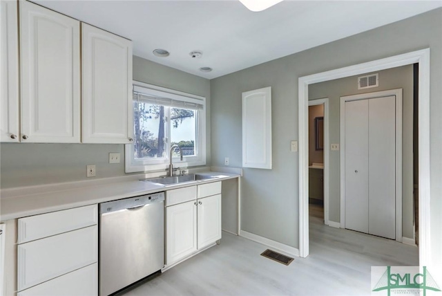 kitchen with light wood-type flooring, white cabinetry, dishwasher, and sink