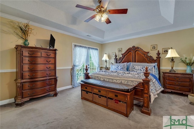 carpeted bedroom with a textured ceiling, ceiling fan, ornamental molding, and a tray ceiling