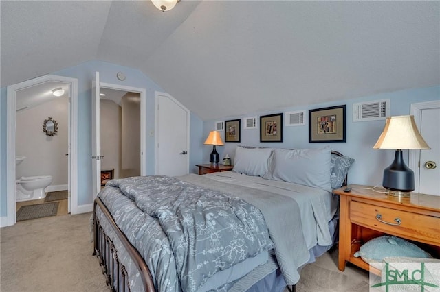 carpeted bedroom featuring ensuite bathroom, vaulted ceiling, and a textured ceiling