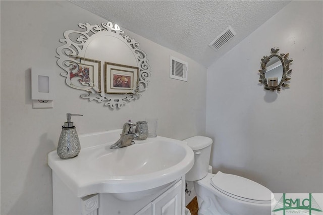 bathroom with a textured ceiling, toilet, and vanity