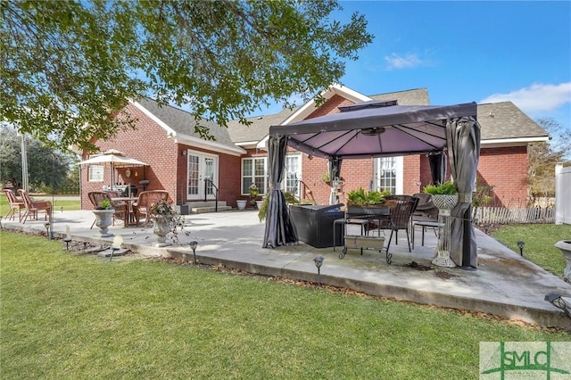 back of property with a patio area, a gazebo, and a lawn