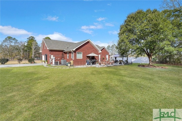 back of house featuring a lawn and central air condition unit