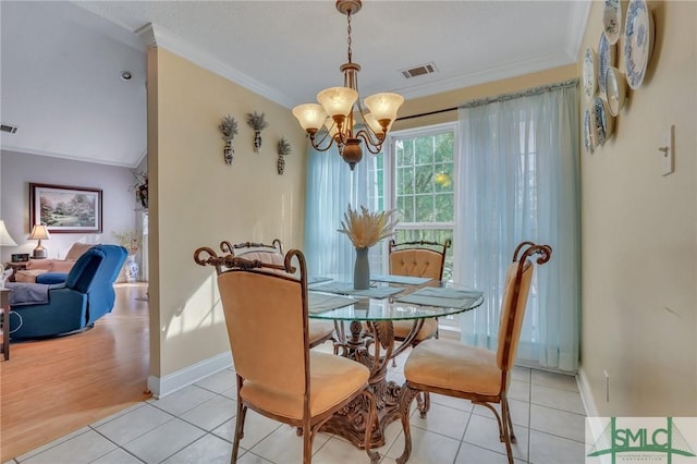 dining area featuring light tile patterned floors, ornamental molding, and a notable chandelier