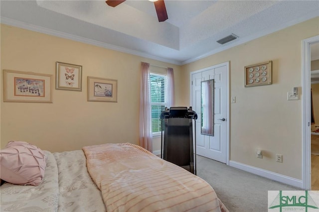 bedroom with light carpet, ceiling fan, a raised ceiling, a closet, and a textured ceiling