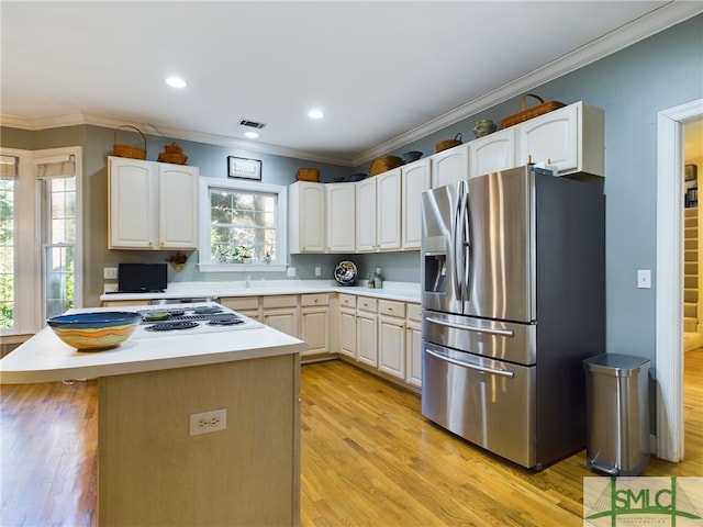 kitchen featuring light hardwood / wood-style floors, crown molding, stainless steel appliances, and a center island