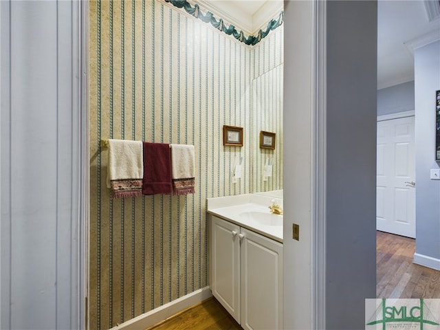 bathroom with vanity, crown molding, and hardwood / wood-style floors