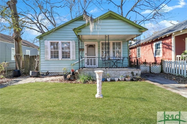 bungalow-style house with a front lawn and covered porch