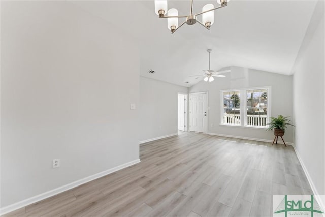 unfurnished living room with ceiling fan with notable chandelier, vaulted ceiling, and light wood-type flooring