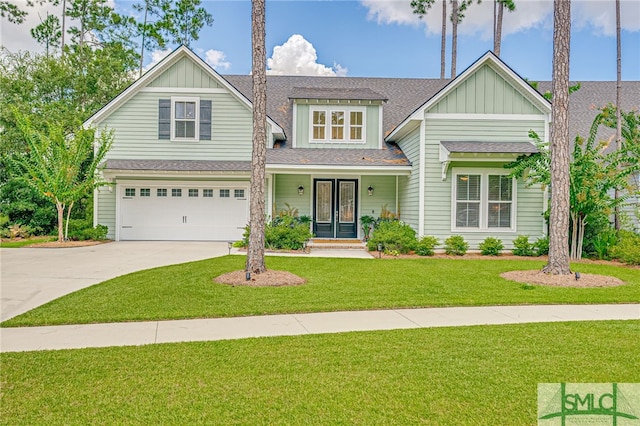 view of front of property featuring a front lawn, a garage, and covered porch