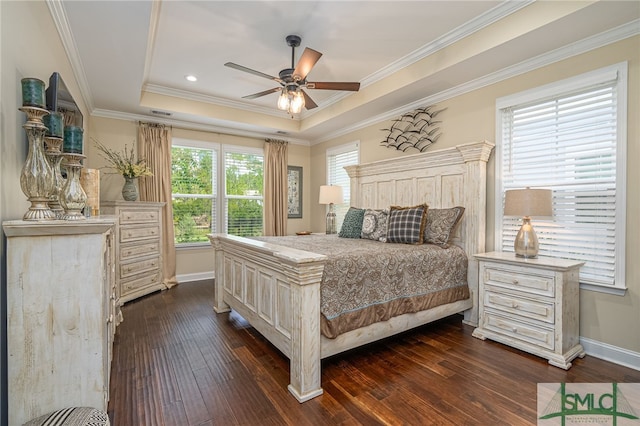 bedroom featuring ceiling fan, a raised ceiling, dark wood-type flooring, crown molding, and multiple windows