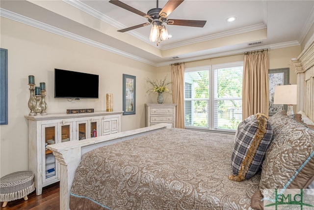 bedroom featuring dark wood-type flooring, ceiling fan, ornamental molding, and a raised ceiling