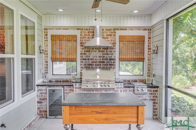 sunroom / solarium with ceiling fan, a wealth of natural light, and beverage cooler