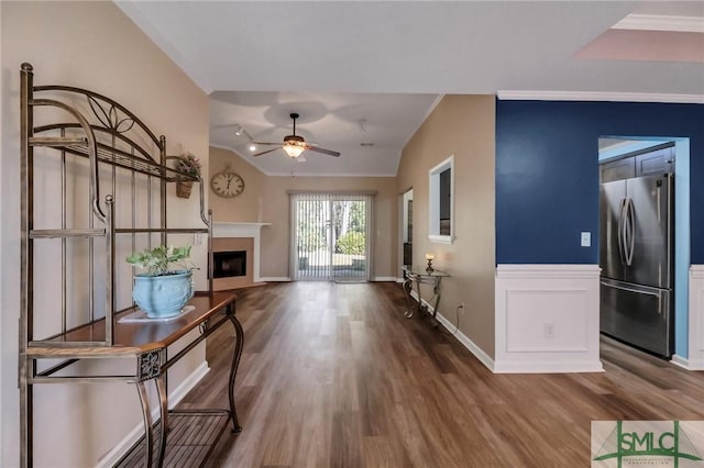 unfurnished living room featuring ceiling fan, ornamental molding, and hardwood / wood-style floors