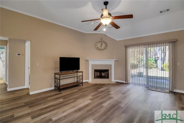 unfurnished living room featuring lofted ceiling, wood-type flooring, ornamental molding, ceiling fan, and a tiled fireplace