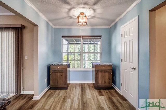 entryway featuring hardwood / wood-style flooring, a textured ceiling, and ornamental molding