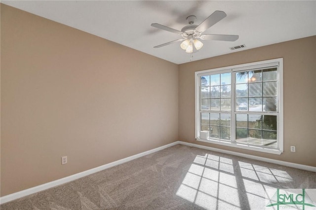empty room featuring ceiling fan and carpet