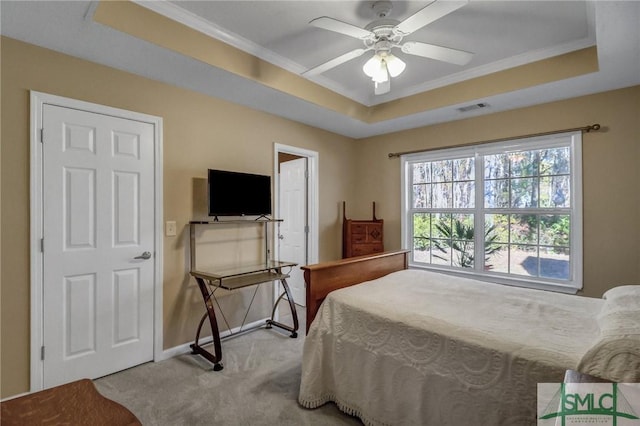 bedroom featuring ceiling fan, light colored carpet, and a raised ceiling