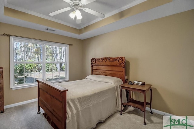 bedroom with light carpet, ceiling fan, ornamental molding, and a tray ceiling
