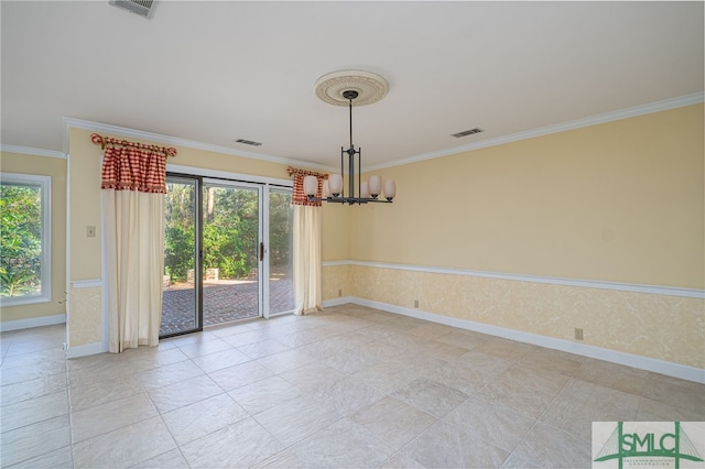 spare room featuring a wealth of natural light, crown molding, and a notable chandelier