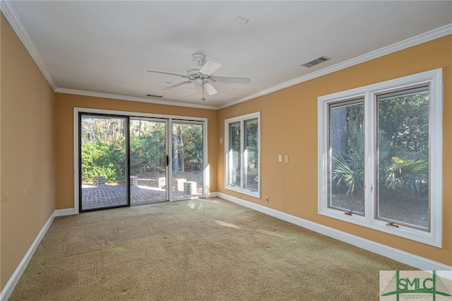 carpeted spare room featuring ceiling fan and crown molding