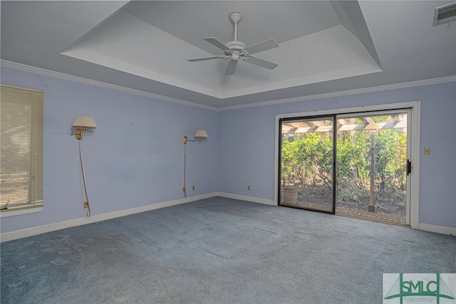 carpeted empty room featuring ceiling fan, crown molding, and a tray ceiling