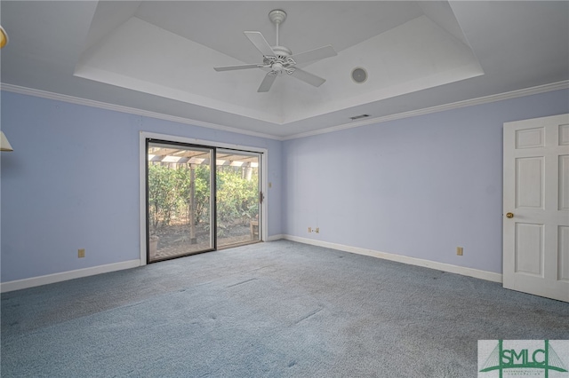 carpeted spare room featuring ceiling fan, a tray ceiling, and crown molding