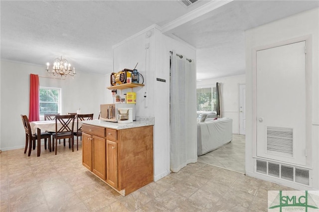 kitchen featuring decorative light fixtures, an inviting chandelier, and ornamental molding