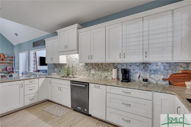 kitchen with white cabinets, dishwasher, tasteful backsplash, sink, and vaulted ceiling