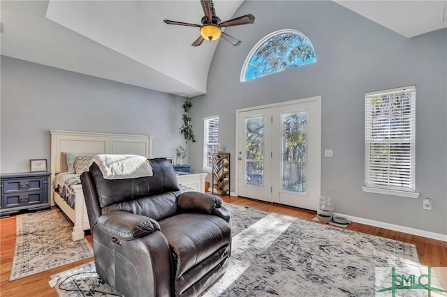 bedroom with ceiling fan, access to exterior, light hardwood / wood-style flooring, and high vaulted ceiling