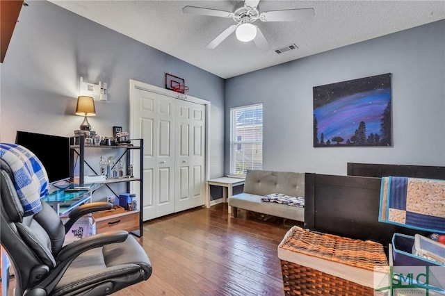 office space with a textured ceiling, ceiling fan, and wood-type flooring