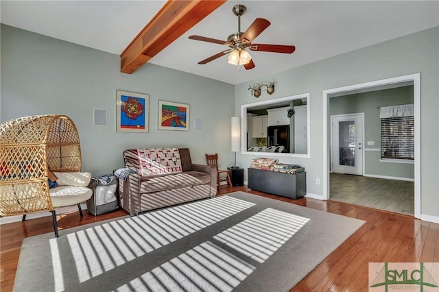 living room with ceiling fan, wood-type flooring, and beamed ceiling