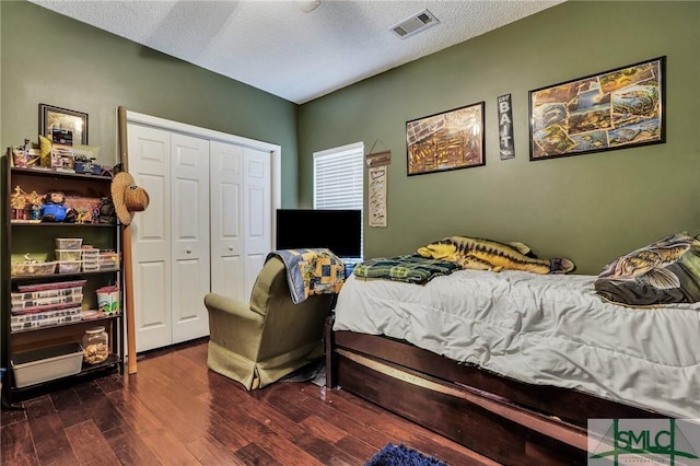 bedroom featuring a textured ceiling, a closet, and dark hardwood / wood-style floors