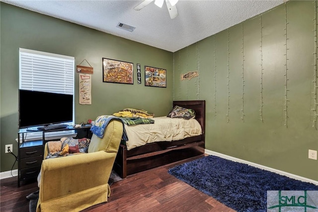 bedroom featuring a textured ceiling, ceiling fan, and dark hardwood / wood-style floors