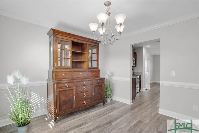 dining space featuring a chandelier, crown molding, and light hardwood / wood-style floors