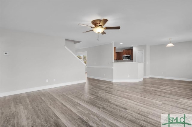 unfurnished living room featuring light hardwood / wood-style flooring and ceiling fan